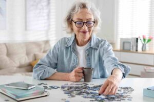 persona prossima alla pensione fa un puzzle e sorseggia un the