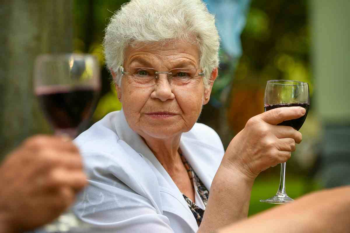 donna festeggia la pensione brindando col vino