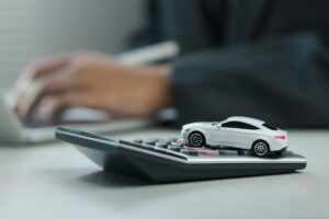 calcolatrice e auto in miniatura e uomo al pc