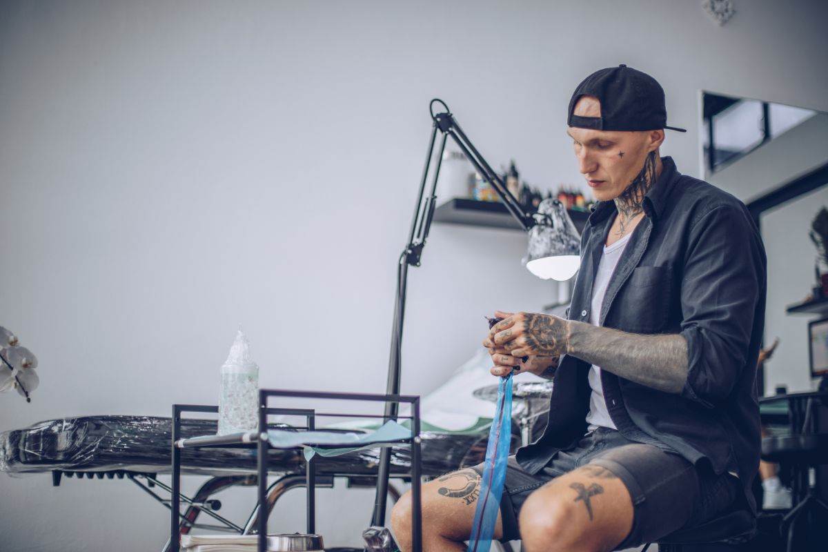 tatuatore all'interno del suo studio