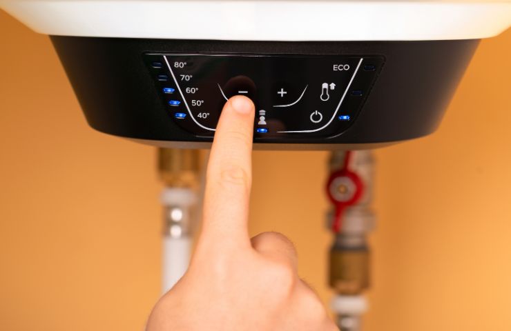 donna che preme pulsante scaldabagno